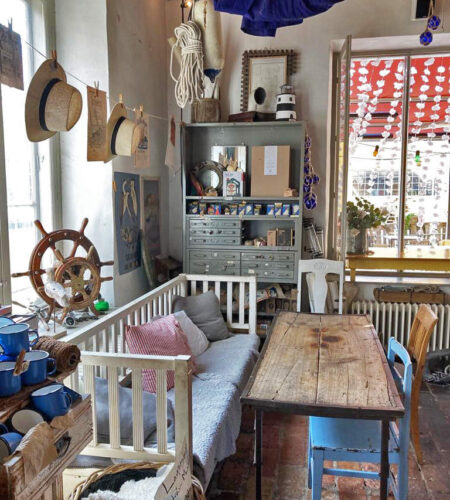 The interior of Skroten café. An assortment of benches and chairs, surrounded by nautical items as decor.