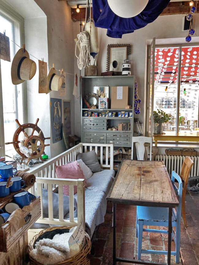 The interior of Skroten café. An assortment of benches and chairs, surrounded by nautical items as decor. 